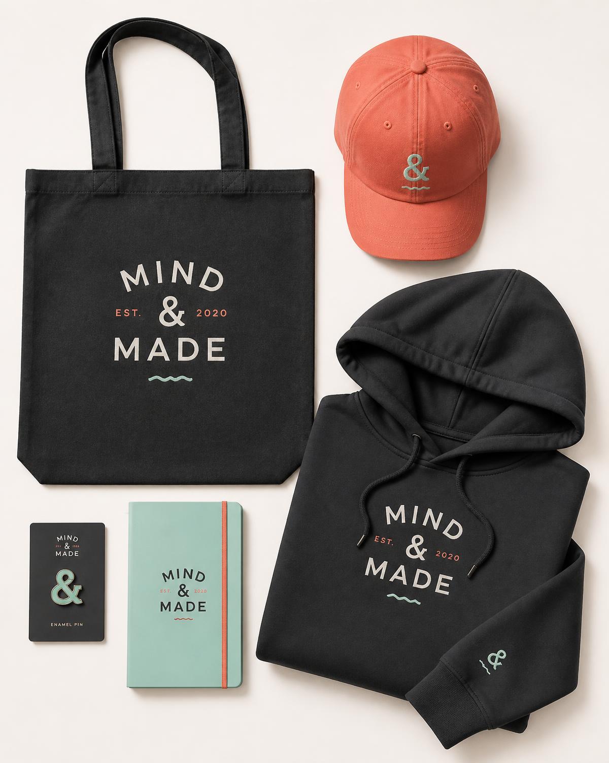Conjunto de merchandising de marca: bolsa, gorra coral, sudadera negra, pin y libreta menta